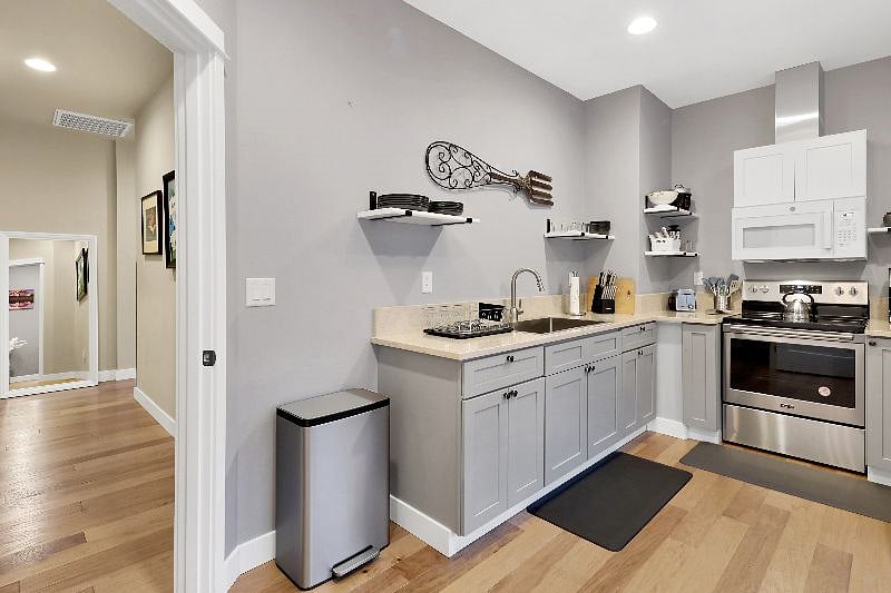 Quartz counter tops, stainless sink, stainless steel range, and a fully stocked kitchen.