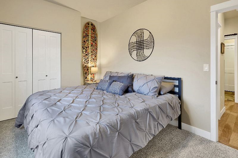 Bedroom with a new Casper King mattress, dresser, closet supplies with hangers and suitcase rack,.