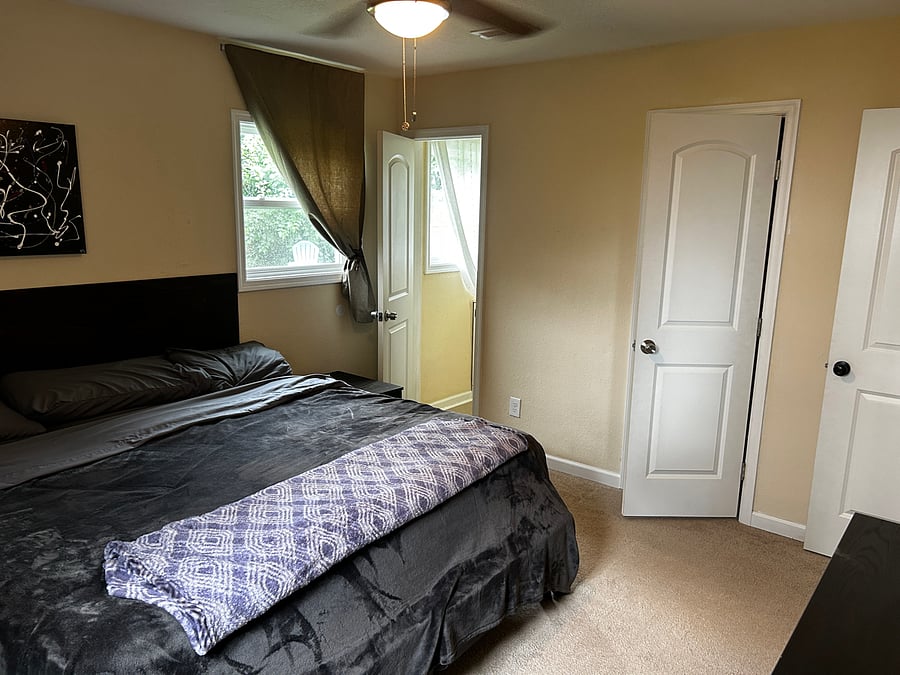 Bedroom 4 has a King size Bed- Walk in Close - 6 Drawer Dresser -a private 1/2 bathroom - 40 " Smart TV with a swivel head mounted on the wall. Located at the end of the hall on on the Left hand side and has two windows overlooking the private fully fenced backyard.