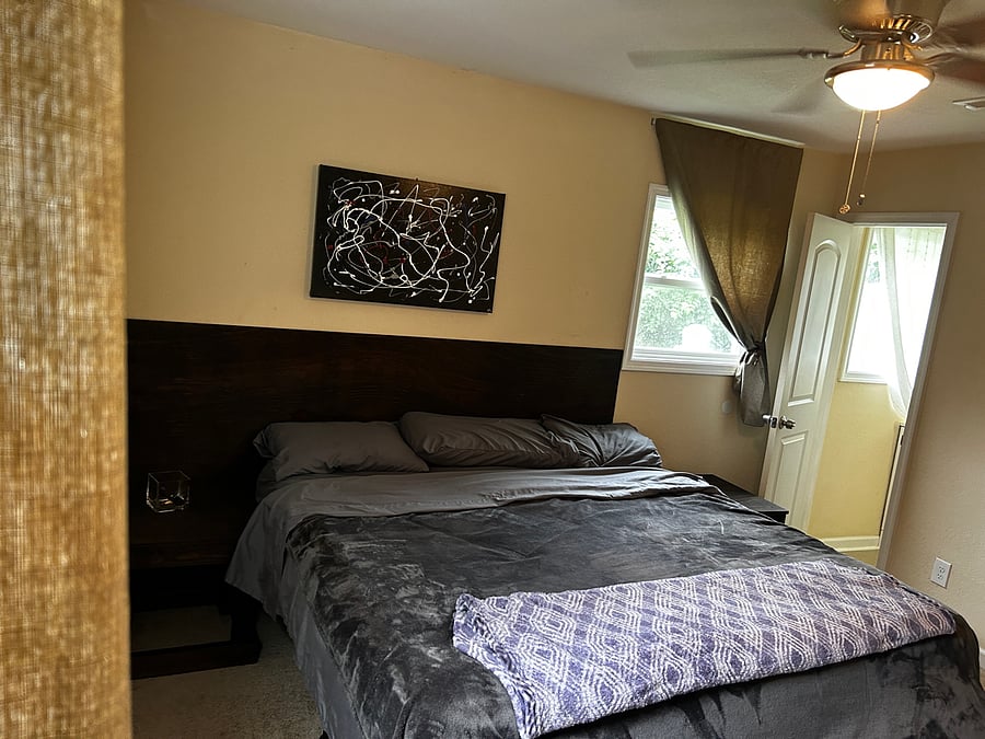 Bedroom 4 has a King size Bed- Walk in Close - 6 Drawer Dresser -a private 1/2 bathroom - 40 " Smart TV with a swivel head mounted on the wall. Located at the end of the hall on on the Left hand side and has two windows overlooking the private fully fenced backyard.