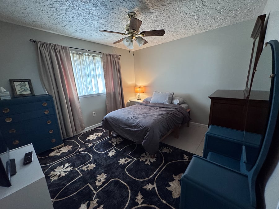 Spacious third bedroom with full size bed and vanity.