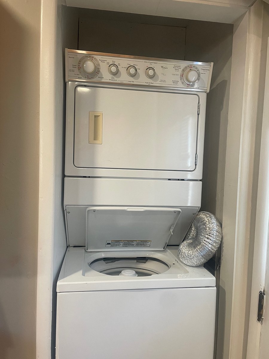 Full sized stackable washer and dryer in studio space.