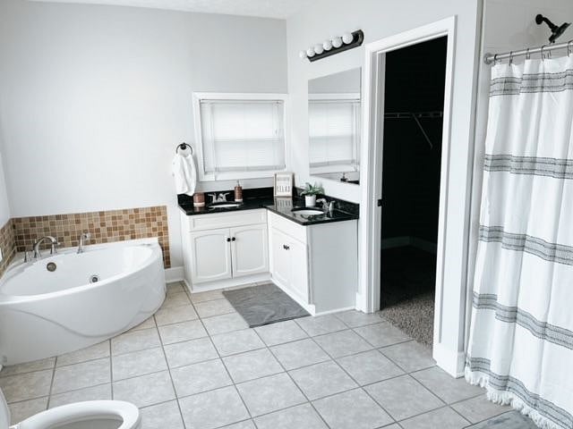 Master bathroom with standing shower, jacuzzi, and walk in closet