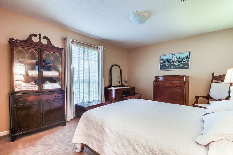 Bedroom with glass-front cabinet for that holds linens.