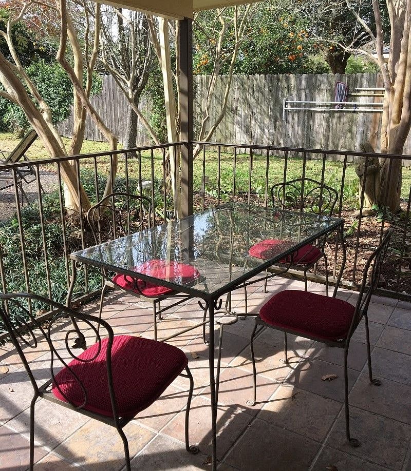 There are three outdoor tables: two on the shady patio and one by the sunny pool