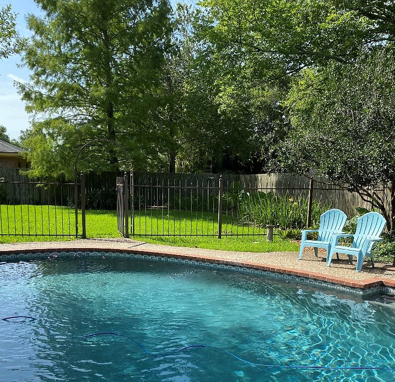 View from pool into side yard; side yard is large and great for the yard games that are kept in the garage.