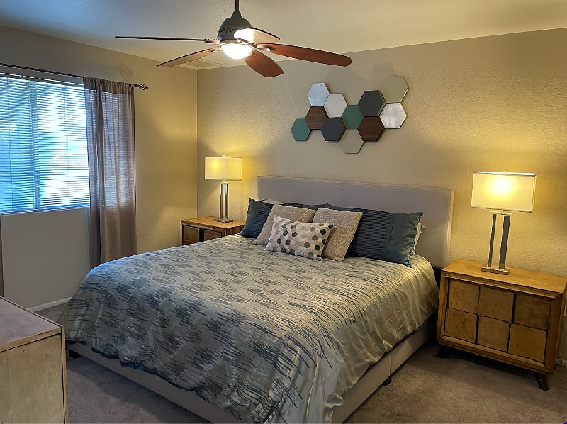 A comfy king size bed is located in the master bedroom, and there is plenty of storage space in the mid-century modern dressers and nightstands.