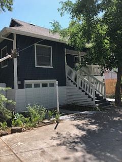 View of front of house. Upper level is 2b/2b with garage on lower left. Right side garage is for lower 1bd/1b unit.