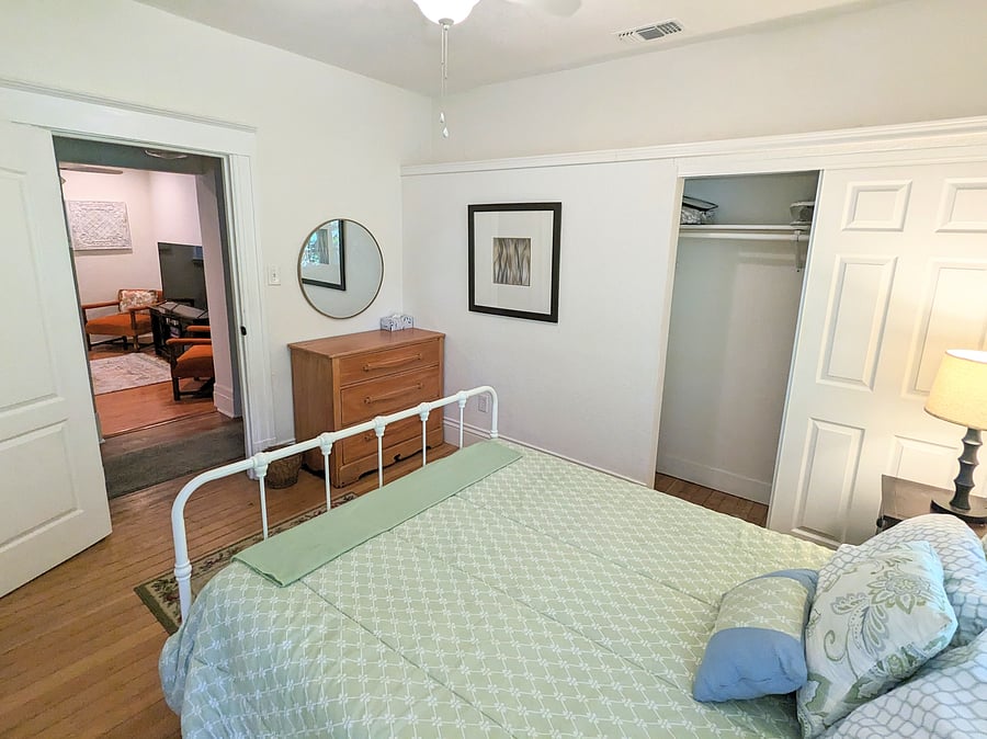 Master bedroom with a queen-sized bed, high ceilings and great storage.
