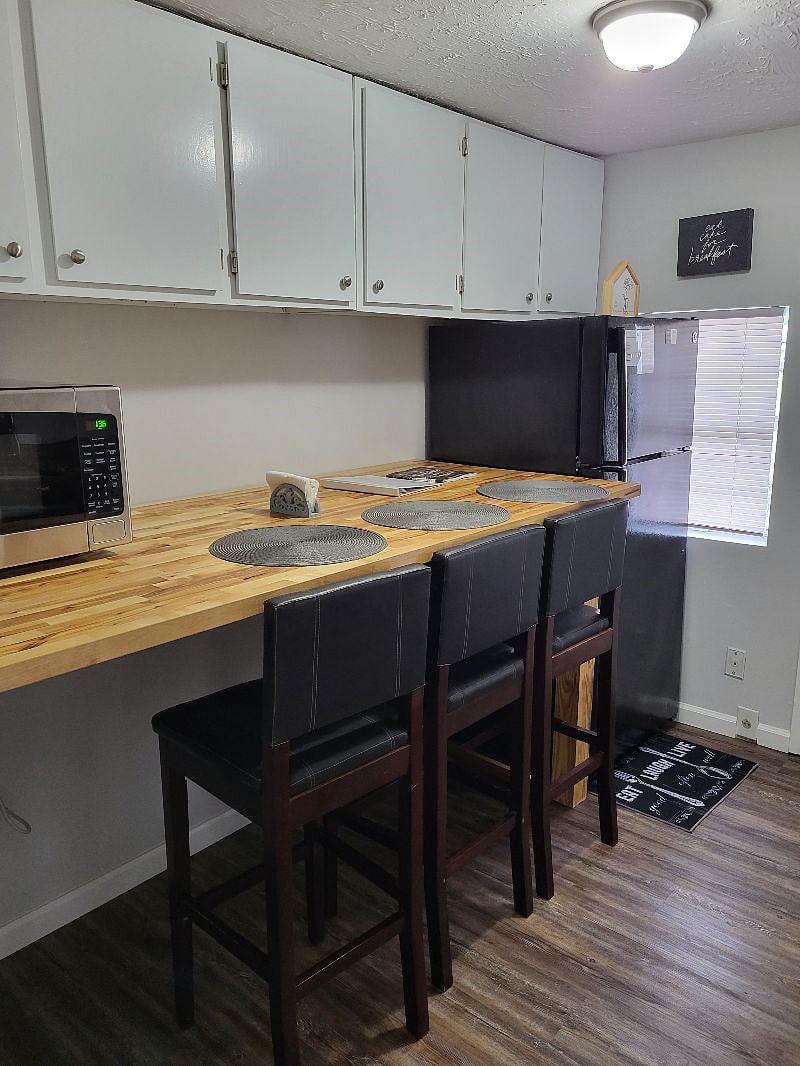 In kitchen dining with large bar with 3 bar stools. 