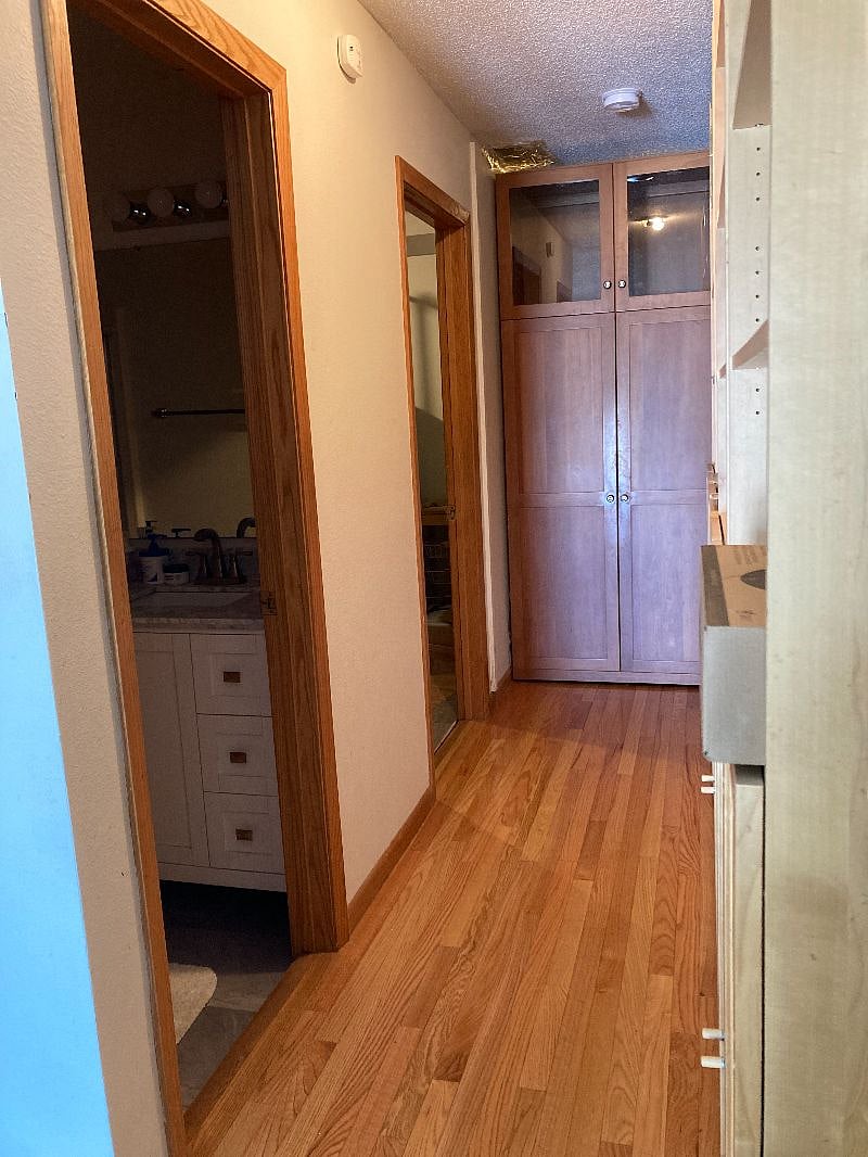 A hallway with a mobile cabinet separating the lower level from the second floor.