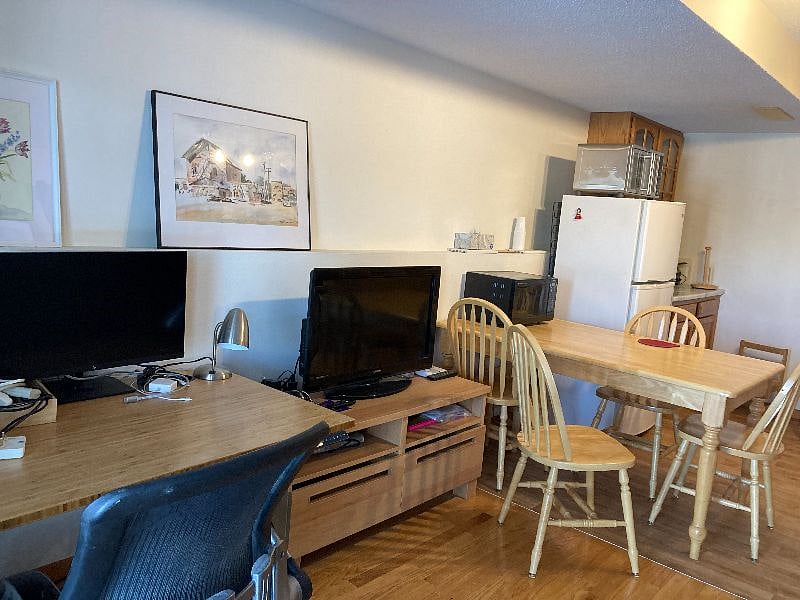 A living room desk and a kitchenette