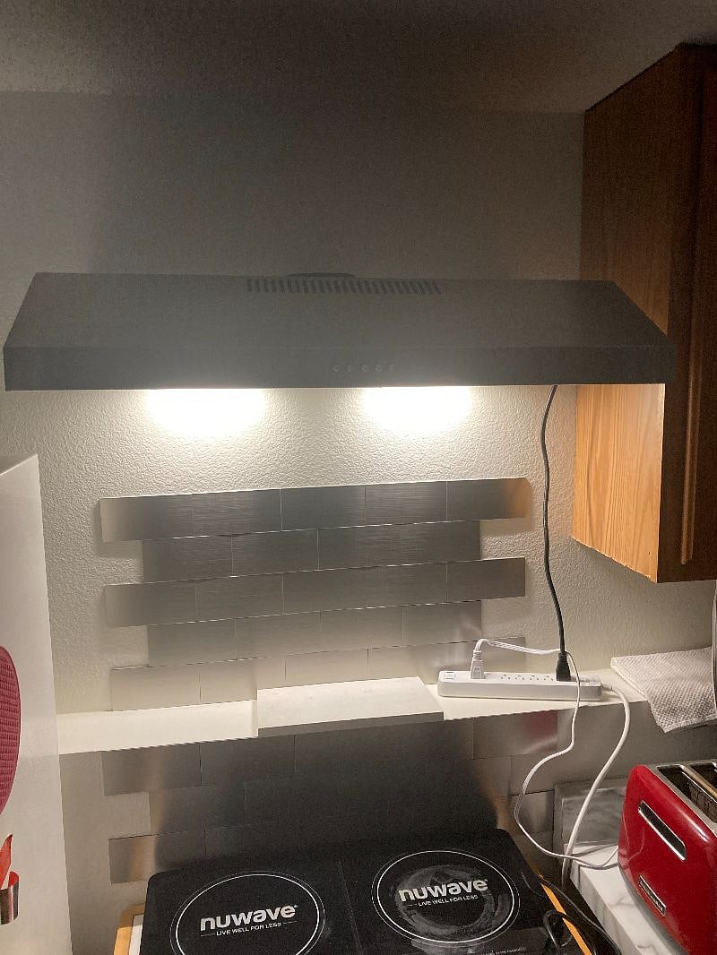 Exhaust hood in the kitchenette above the induction double burner