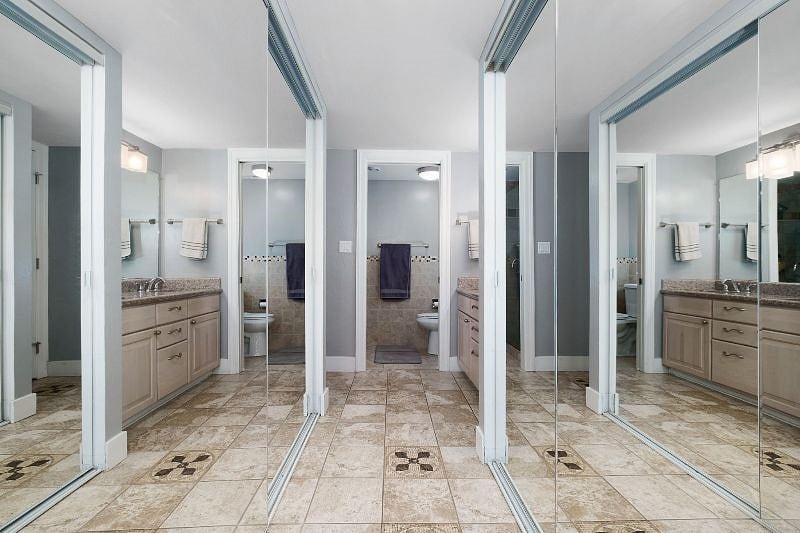 The master bedroom features stunning all-glass dual parallel closets that provide ample space for all your clothing and essentials.
These closets lead directly to the spacious ensuite bathroom, complete with a sleek dual-sink countertop and a walk-in shower, creating the perfect blend of style and functionality for your stay.
