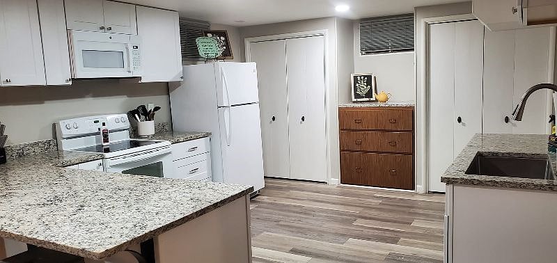 Kitchen with granite countertops also has undercabinet lighting