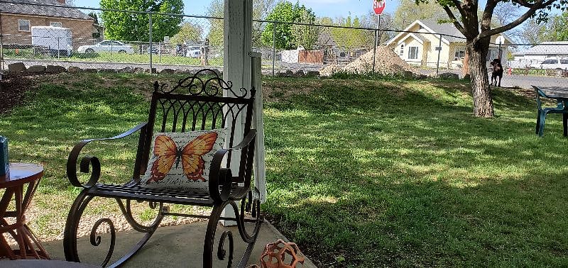Covered patios seating, fenced yard and large mature trees in backyard