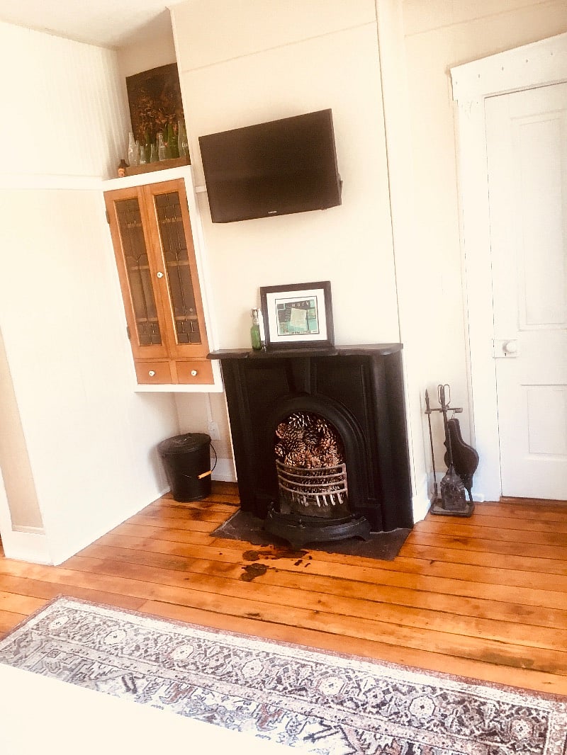 Livingroom with original parlor fireplace from the 1800s!! It is sealed now and decorative , but the HVAC works great! -No more cutting firewood!