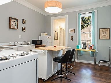 Kitchen coming from dining room. L-R: Stove, sink, micro, refrigerator, coffee maker & toaster