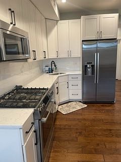 Modern kitchen with gas stove and microwave.