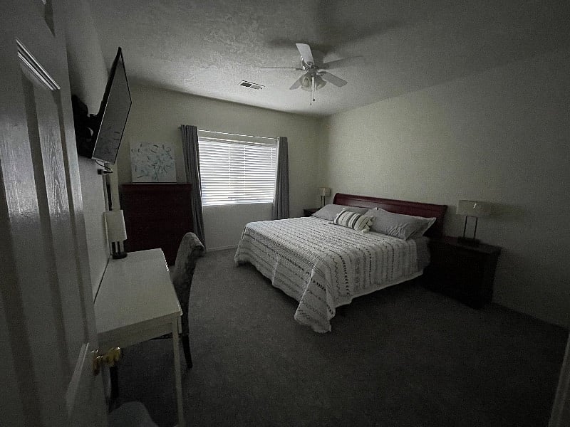 Master Bedroom. King bed, desk, 2 nightstand, dresser, mirror, overhead light with fan, lamps, blackout curtain, and smart TV.