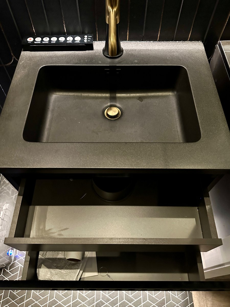 Floating vanity with lots of storage. Two storage drawers that are very deep. Also, there is a medicine cabinet behind the oval mirror on the wall.