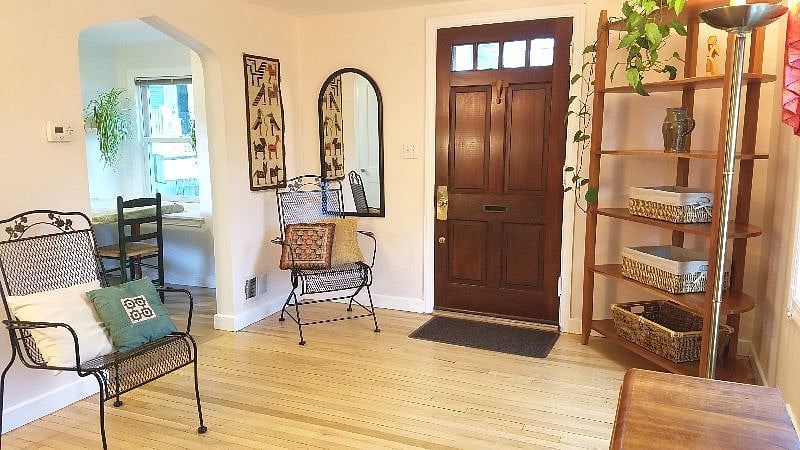 Living room - from bottom of stairs toward entry door and dining room