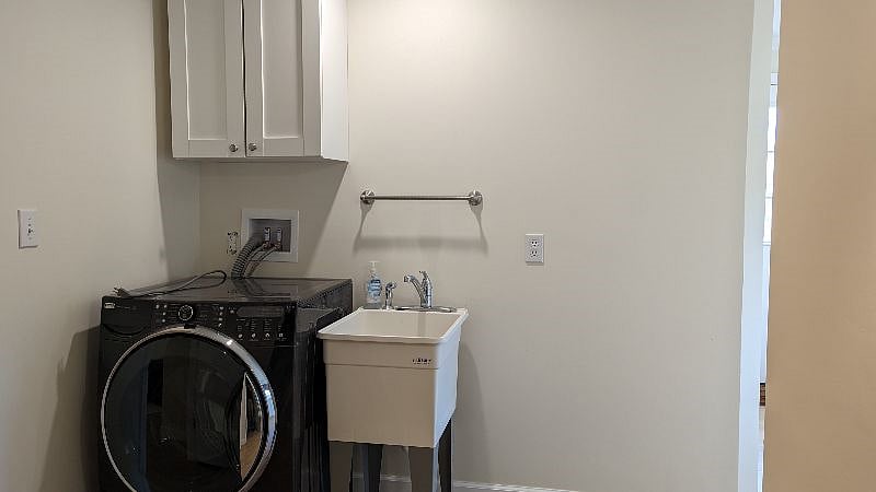 Terrace level front load washer, sink, and storage