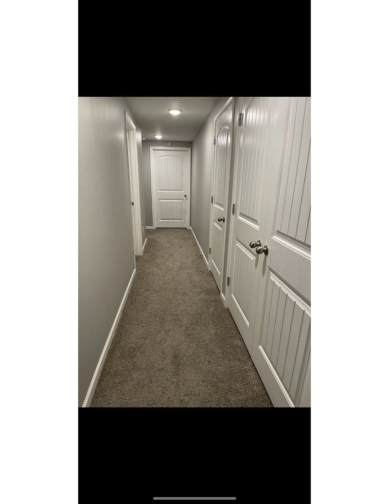 Spacious private hallway with storage areas to the right, bathroom to the left, and bedroom straight ahead