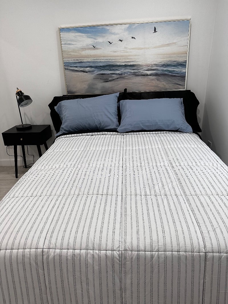 The bedroom is outfitted with a side table, table lamp with usb port.