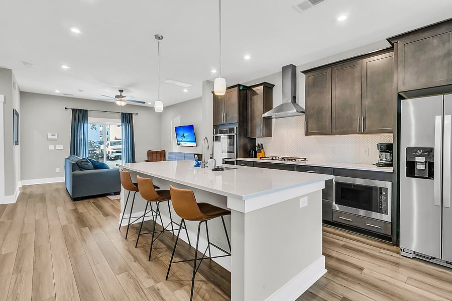 The modern chefs kitchen is fully stocked with all essentials, including a gas cooktop, large pantry, fridge, microwave, and dishwasher. Whether you're preparing a quick meal or a gourmet feast, you'll have everything you need. 