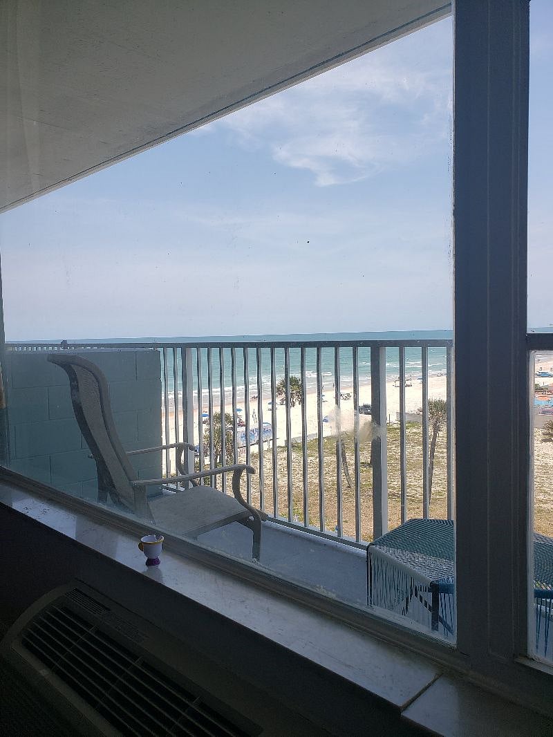 Sitting on the couch looking out the window and enjoy the serenity beach view
