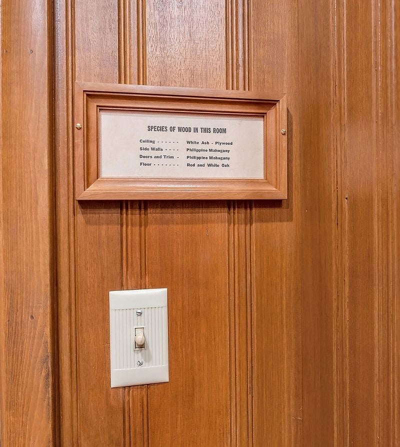 Wall detail, showing wood species sign and rotary light switch