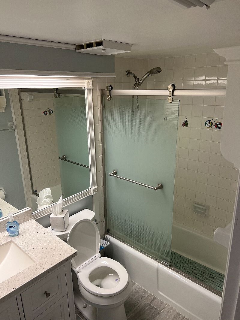 Guest bathroom off hallway has a tub and shower. 