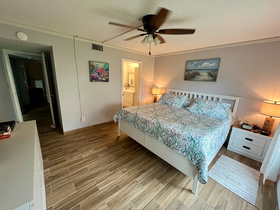 Doorway next to bed leads to large bathroom with walk-in shower and large walk-in closet. 