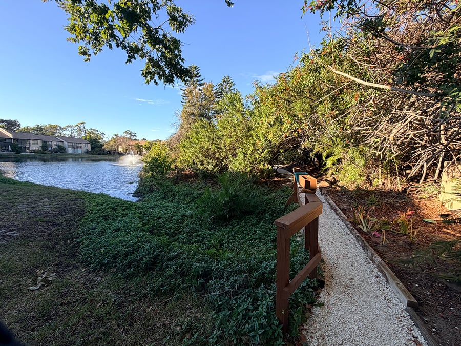 Newly refreshed walking path on the property's east end, offers a serene wooded view of the lake.  