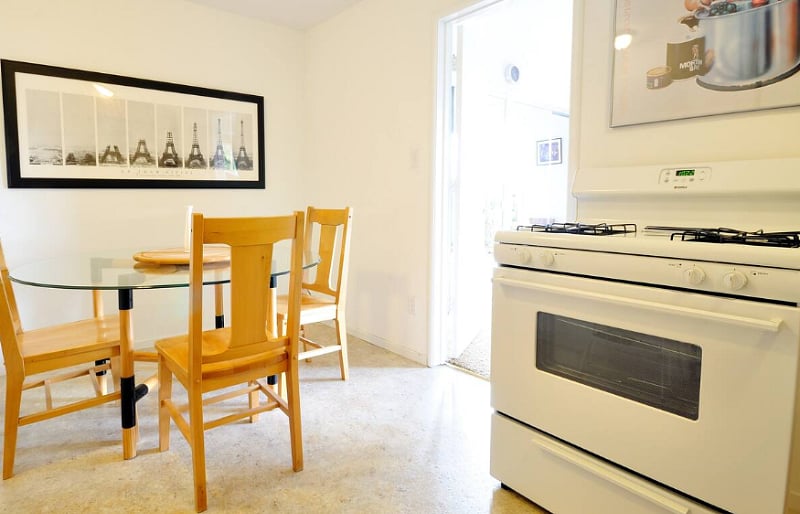 Spacious dining room and table with gas stove in the kitchen.
