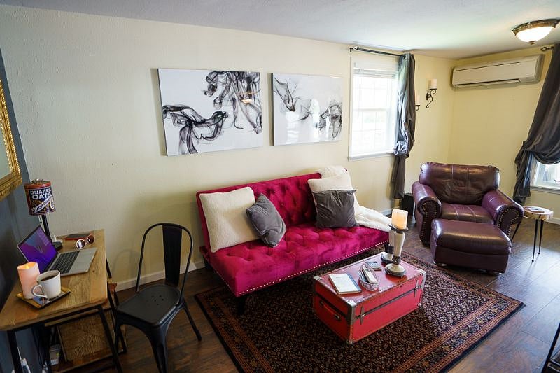View includes desk area (left side), couch, lounge chair in the living room
