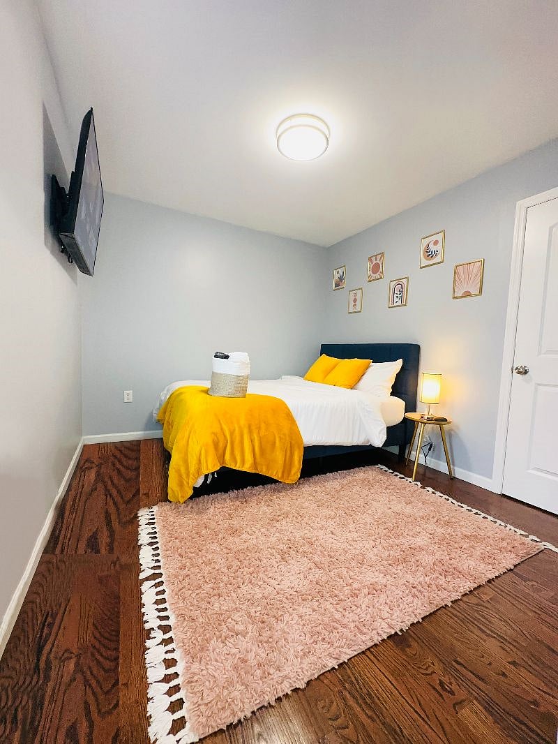 Bedroom 2 with a Full-sized bed, 50-inch Smart TV, charging lamp, and virtual assistant/speaker