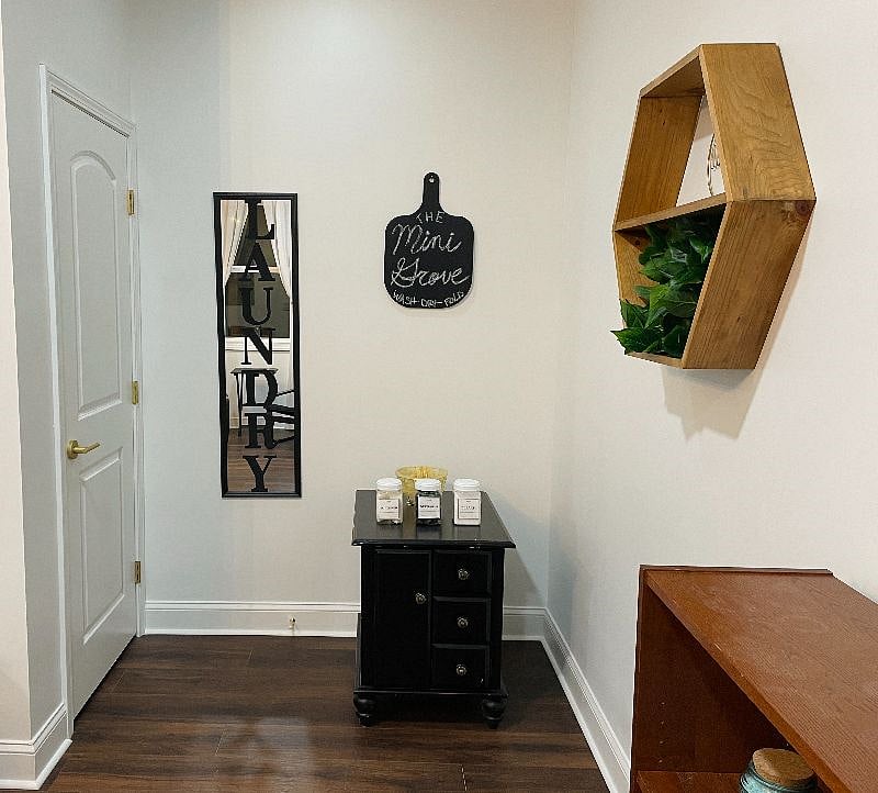 Laundry area. You'll find powder detergent and bleach on the side table along with an iron and mini ironing board inside.