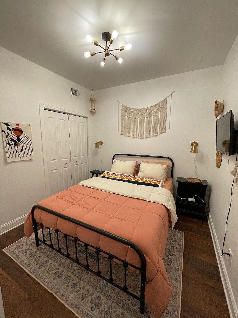 Bedroom complete with a comfy bed, smart TV, clothing rack and dresser in the closets.