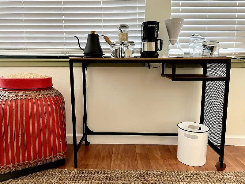 Slim profile laptop desk, laundry hamper and trash bin are some of the amenities in your bedroom. (Tabletop items for scale only. Food prep items will be located in shared kitchen during your stay.)