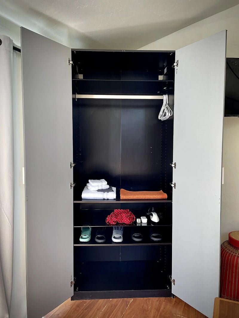 Full closet with tall shelves luggage storage on the bottom, hangers for clothes and more shelves for longer-term stays.