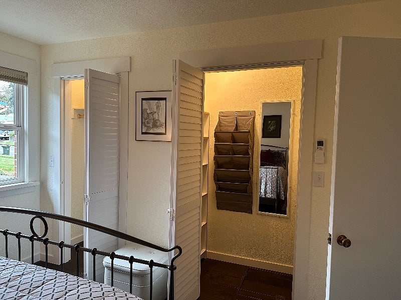 Shoe caddy, shelves and mirror in large closet.