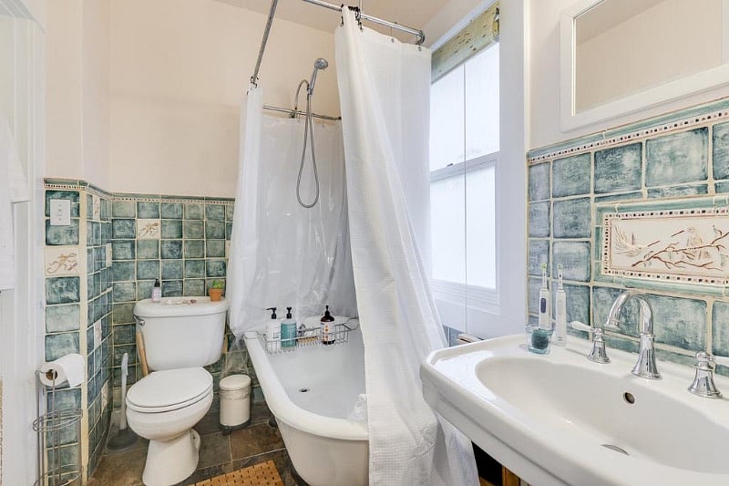 Big, deep claw foot tub and tiled bath.