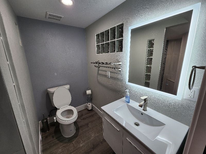 The bathroom features a suspended vanity and a soft-lit mirror allowing you to look your best!