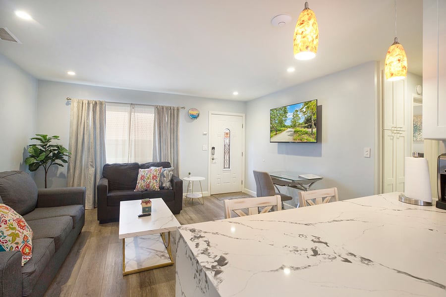 Bright, cozy living area with comfortable seating and plenty of natural light, perfect for relaxing after a day of exploring. Permit #str14-0085