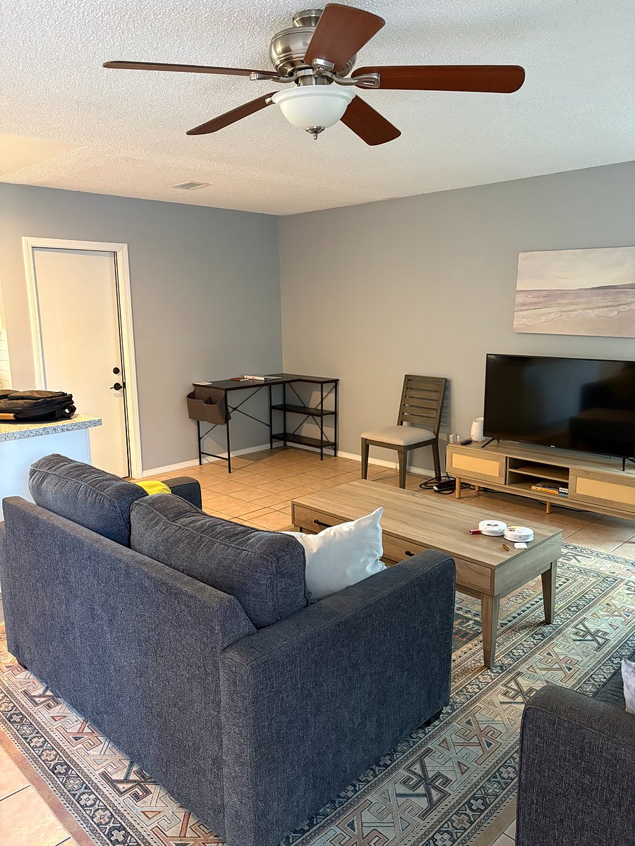 Living room with tv and a desk in the corner.