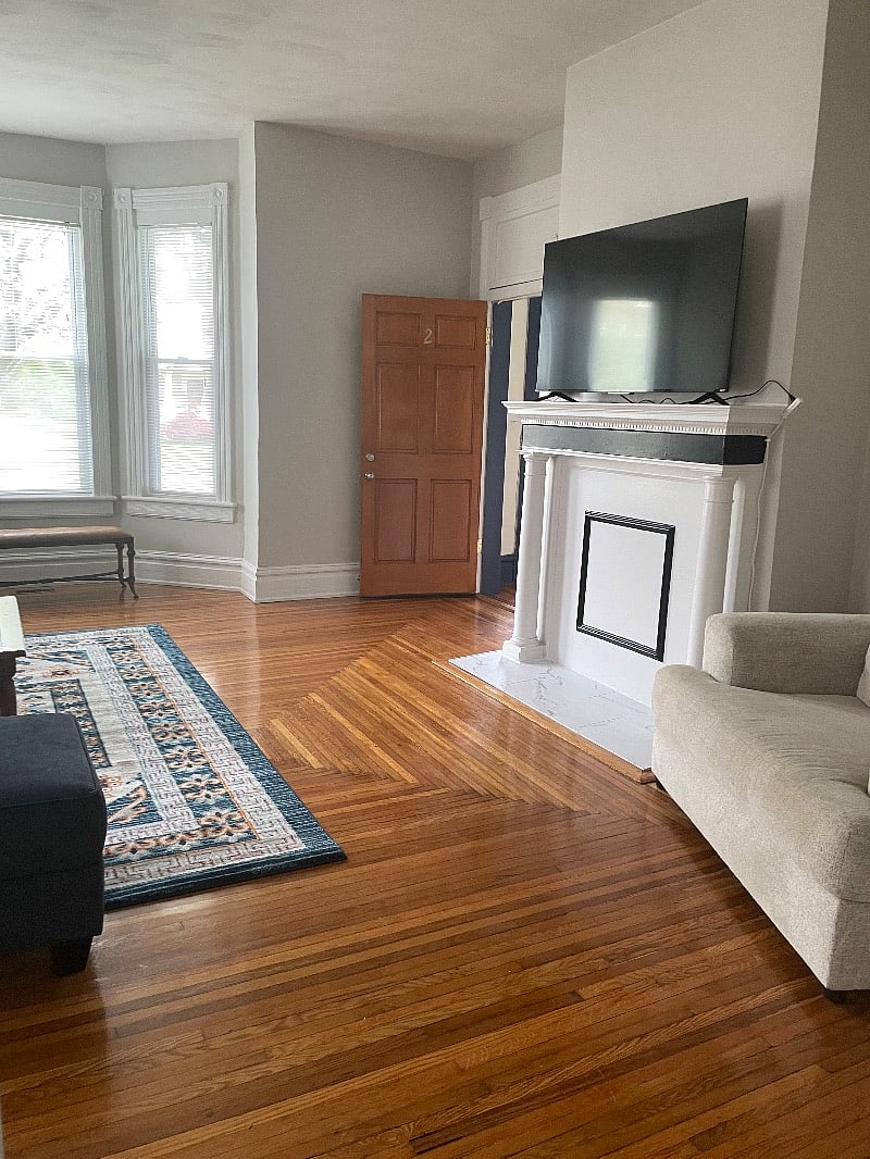 Another angle of spacious front room showing large flat screen TV.