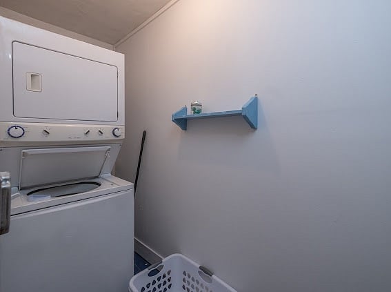 Private laundry room with stackable washer/dryer off kitchen.