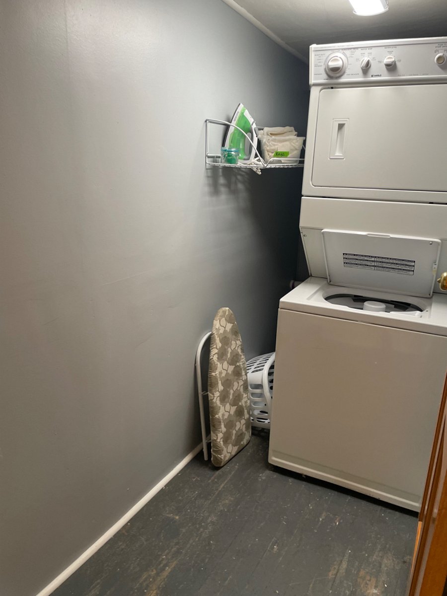 Private laundry room off kitchen with stackable washer/dryer